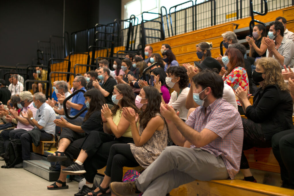 Fotografía donde se ve el público asistente durante el Consejo de Facultad de Artes, en las gradas, aplaudiendo, con tapaboca.