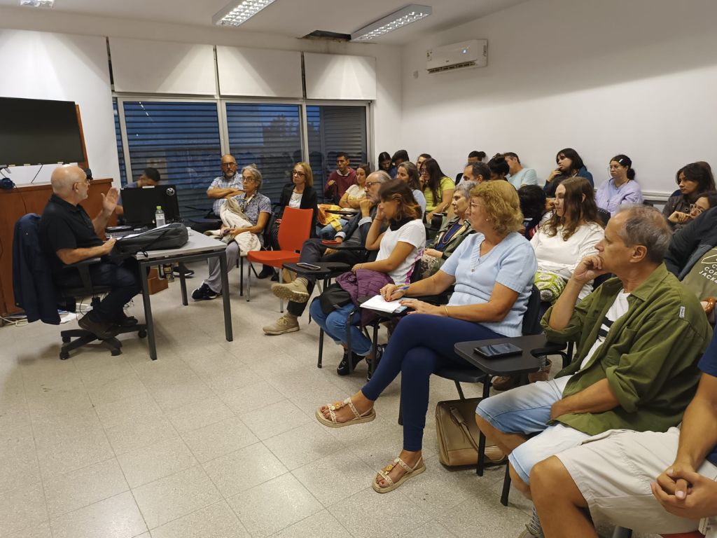 Imagen de salón con personas sentadas mirando hacia adelante atentas a las palabras de Xabier Laka, quien se encuentra sentado adelante