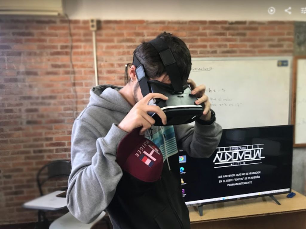 Fotografía de un adolescente en un salón de clase usando lentes de 3D