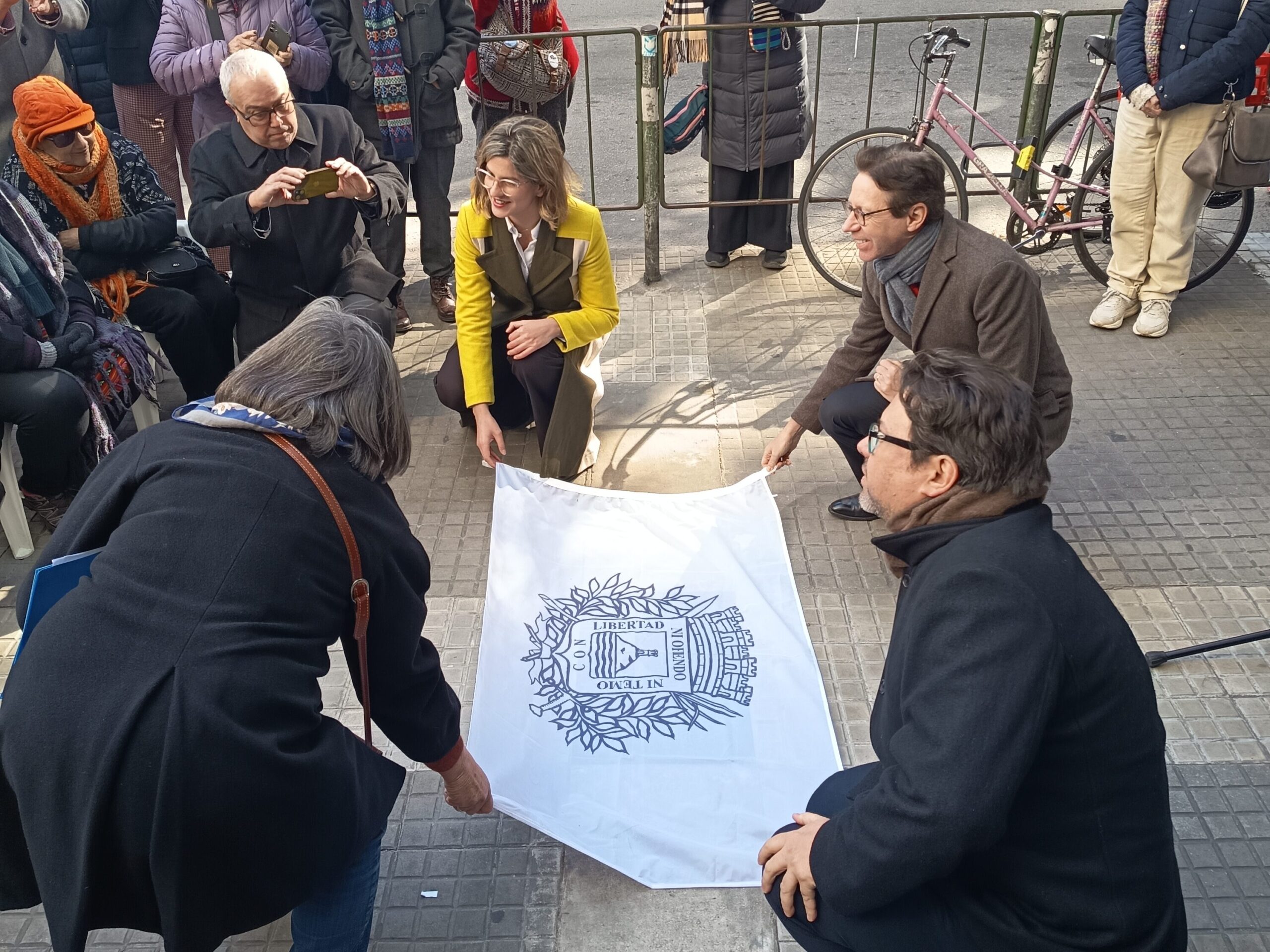 Fotografía del momento en que las y los oradores del evento descubren la placa 