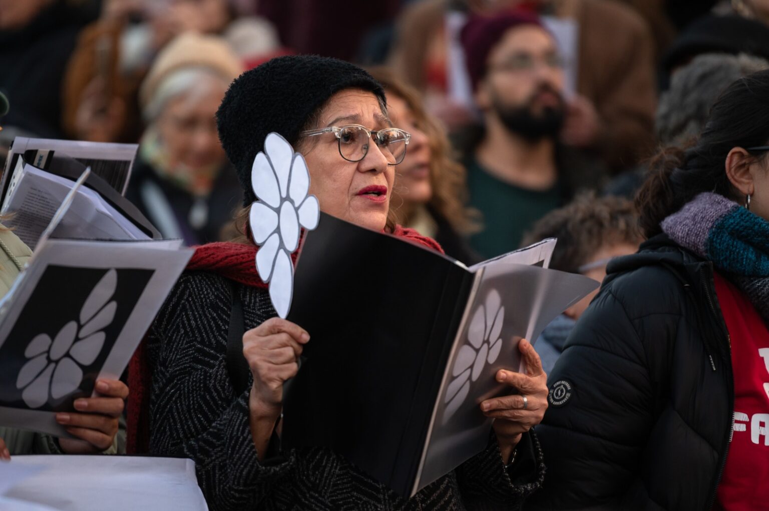 Imagen de señora con partitura y margarita de Madres y Familiares de Detenidos Desaparecidos