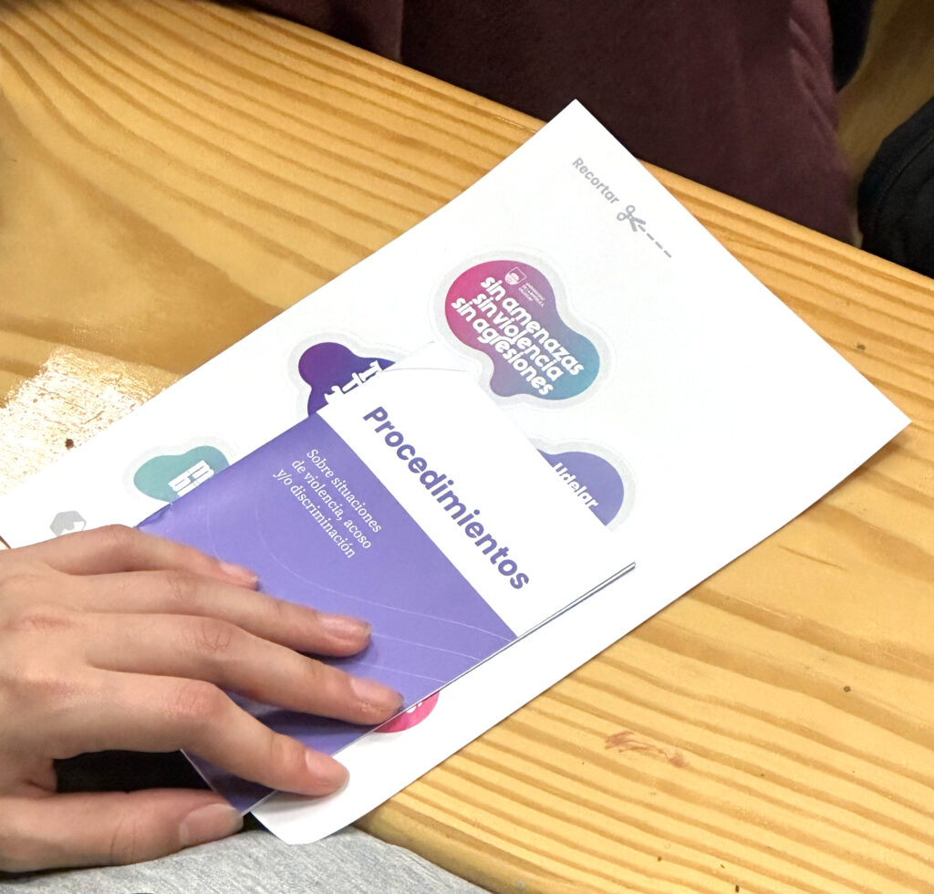 Imagen de una mano sosteniendo un folleto de la Unidad Central sobre Violencia, Acoso y Discriminación (UCVAD)